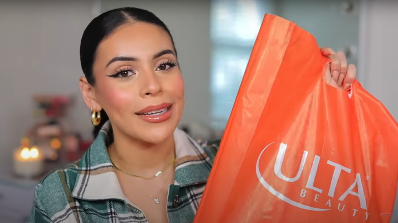Woman holding orange Ulta bag