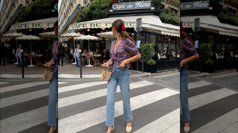 Girl wearing a floral top with boot-cut jeans.