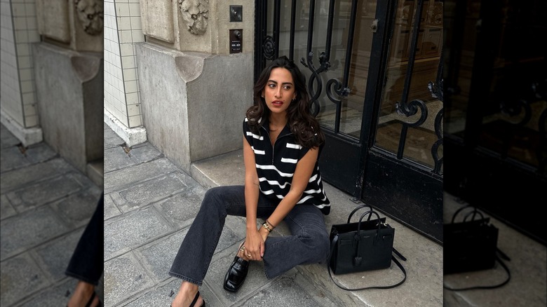 Girl wearing dark black boot-cut denim.