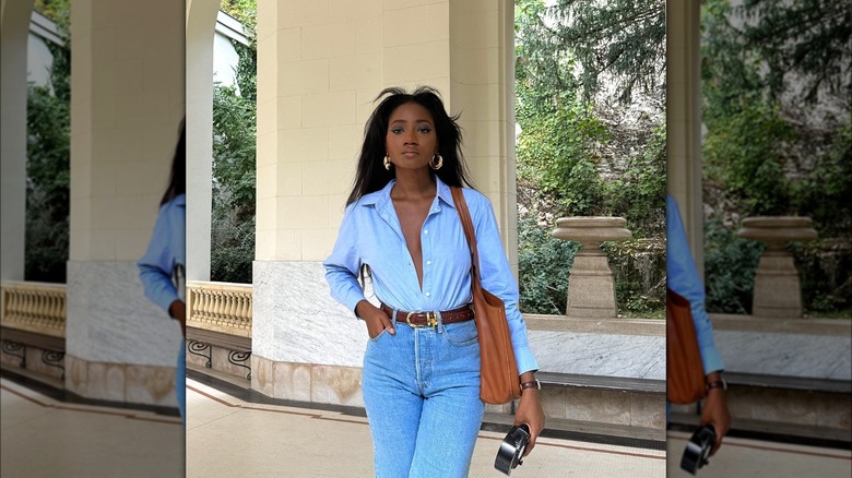 Girl wearing a button-up with boot-cut jeans.