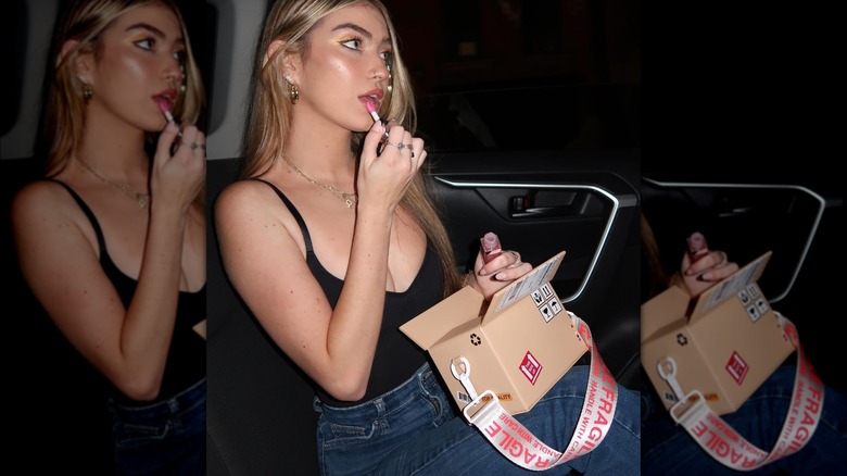 Girl carrying a hyper-realistic box purse