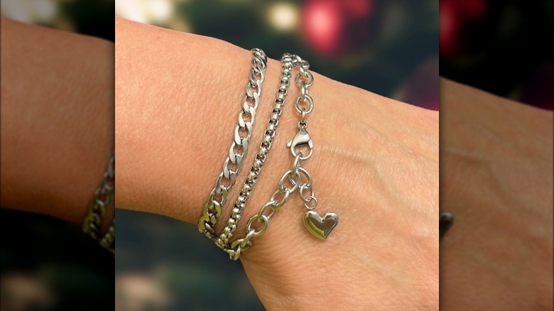 layered silver bracelets on wrist 
