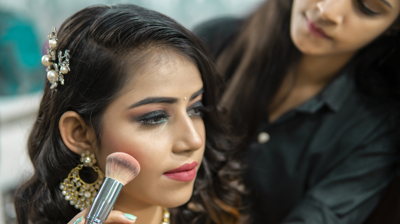 Applying blush to bride