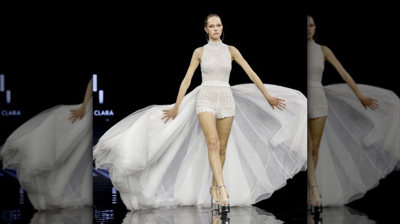 Bridal model wearing romper, train