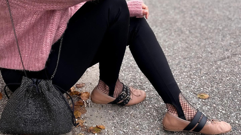 Person wearing stirrup pants with fishnets