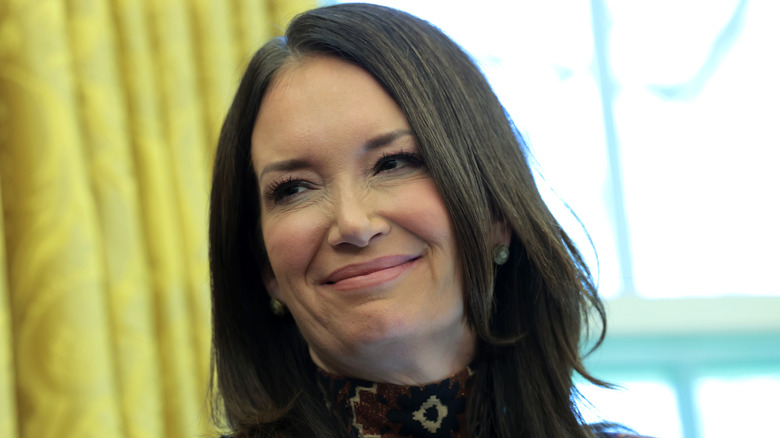 Brooke Rollins wearing a high-neck outfit and smiling