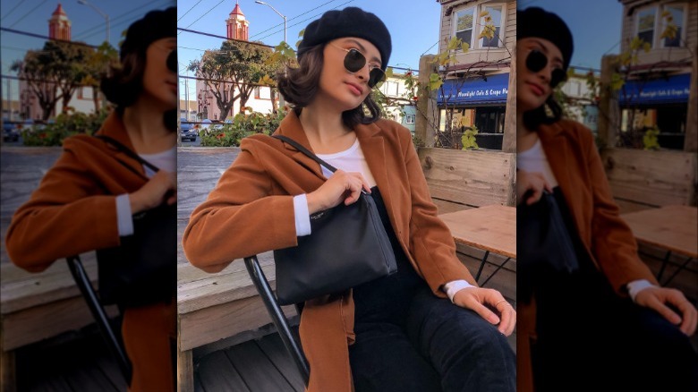 Woman wears brown jacket with white shirt