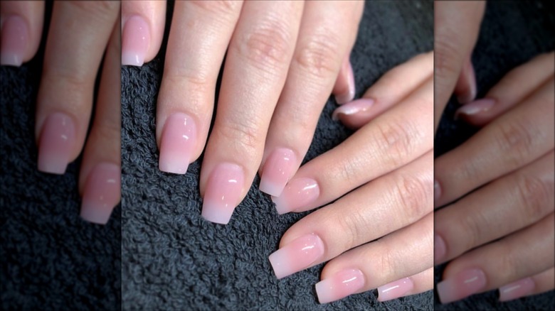 Hand with long ombre pale pink nails