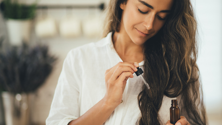 woman applying oil to hair