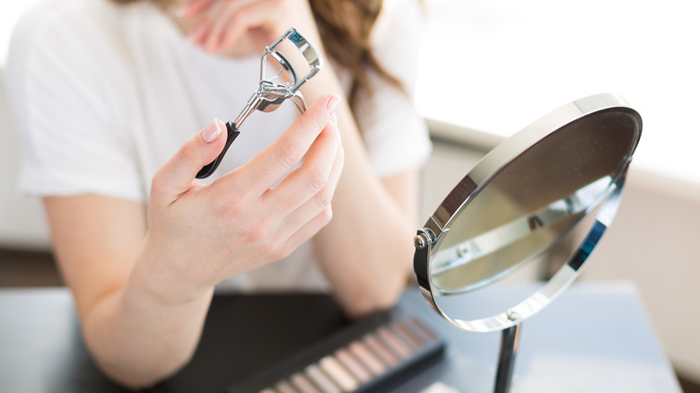 Woman holding eyelash curler 