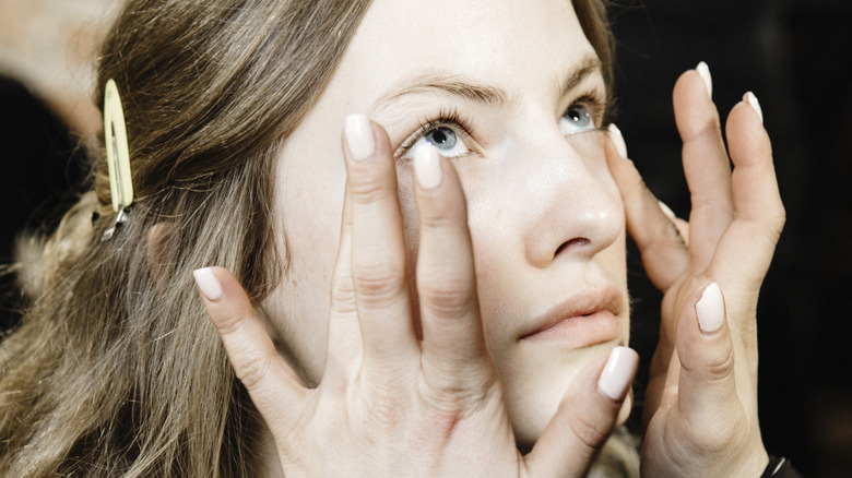 female apply skincare cream