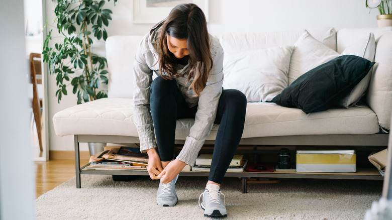woman putting on sneakers
