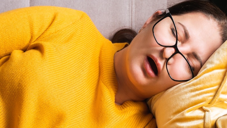 female sleeping on one side mouth open wearing glass