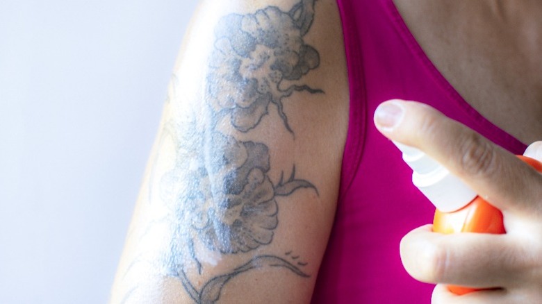 Woman spraying product on skin