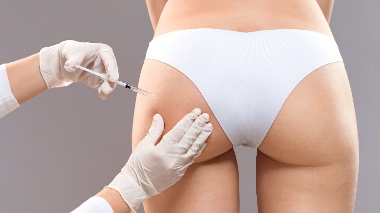 Injecting needle into woman's butt
