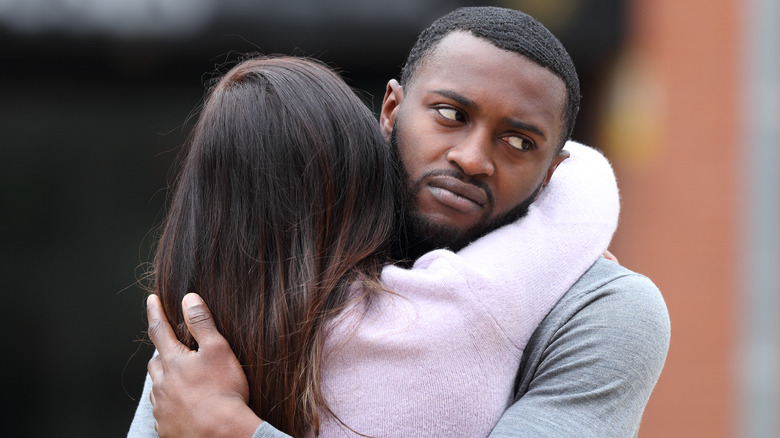 disappointed man hugging woman