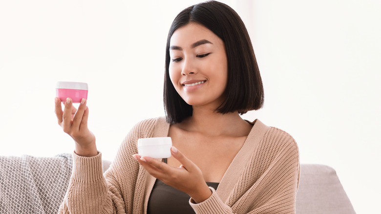 Woman looking at skin cream out of a box