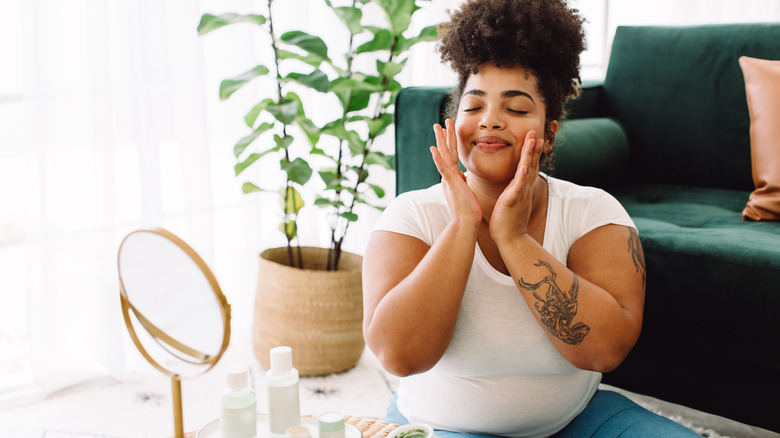 woman applying cream on face