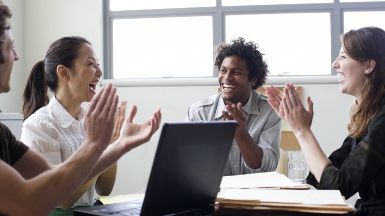 Co-workers laughing and clapping
