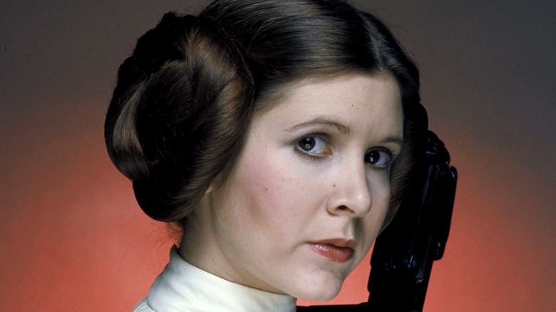 Princess Leia holds a weapon