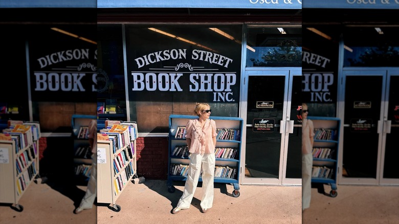 Emma Roberts standing in front of a bookstore