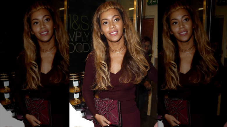 Beyoncé in microbangs and a maroon outfit