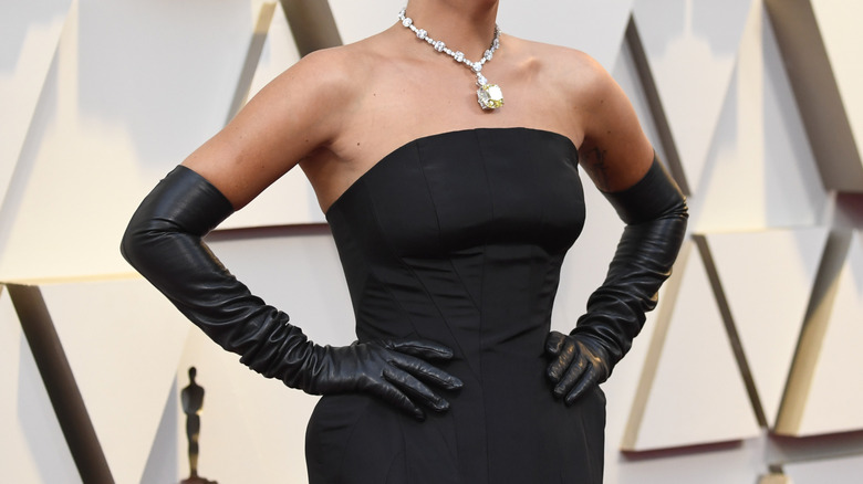 Lady Gaga wearing a black dress and yellow diamond necklace at the 2019 Oscars