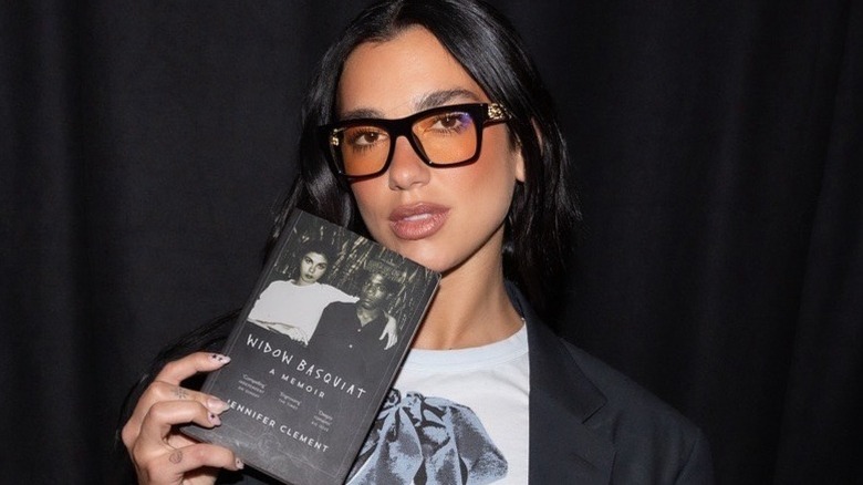Dua Lipa with the book Widow Basquiat