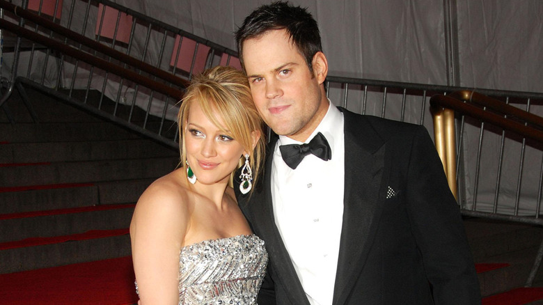 Hilary Duff cuddling up to Mike Comrie while wearing a metallic dress