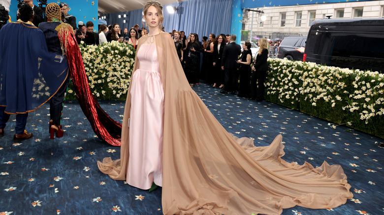 Maya Hawke wears pale pink with a camel cape at the Met Gala