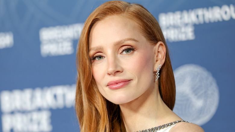 Jessica Chastain at a red carpet event with side-parted orange hair.