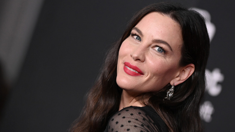 Liv Tyler at a red carpet event in red lipstick.