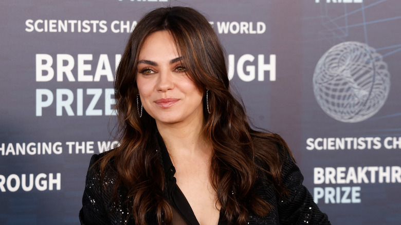 Mila Kunis at a red carpet event with loose waves.