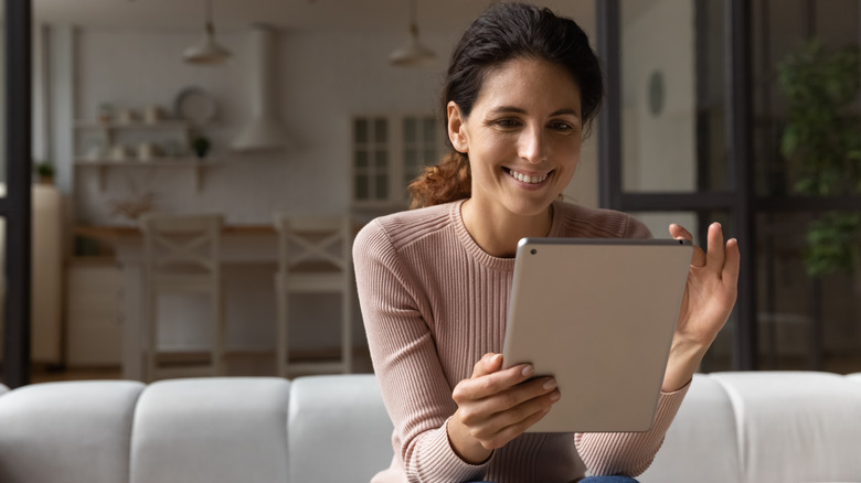 Woman scrolls on tablet