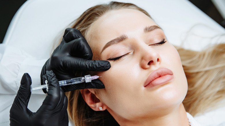 Woman receives cheek filler injection