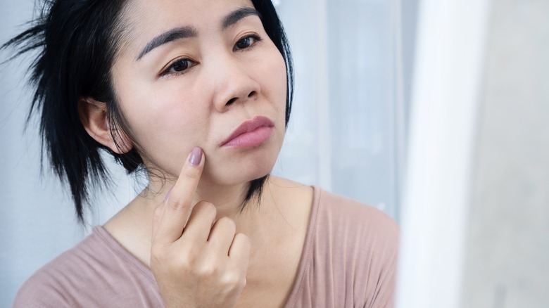Woman examines nasiolabial crease