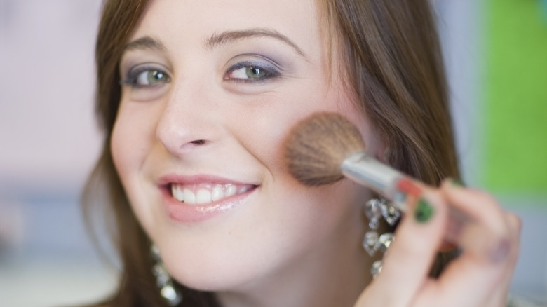 Woman applying blush