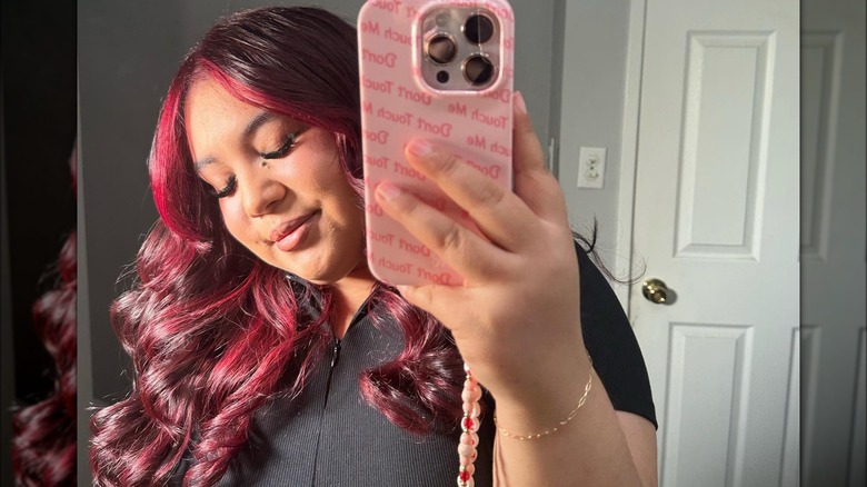 Woman taking selfie black shirt red hair