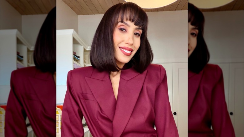 Cheryl Burke smiles in a selfie with bangs and a bob haircut
