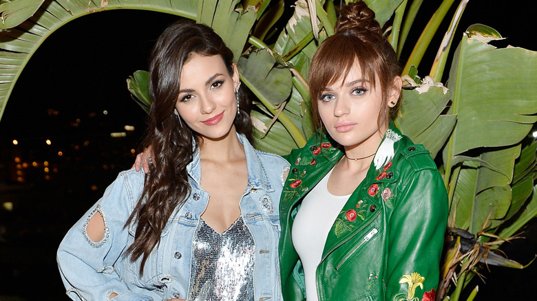 Victoria Justice and Joey King posing together in front of large plants