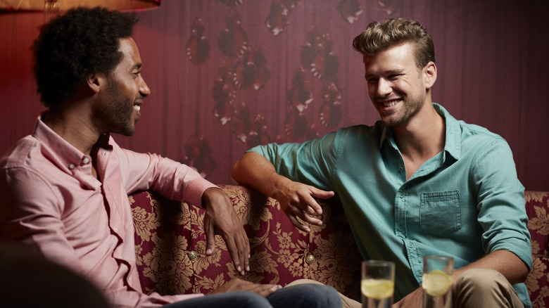 Two men speaking on sofa