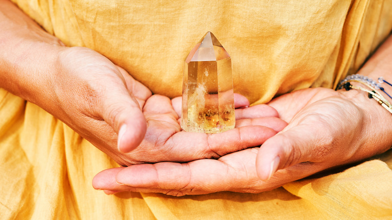 Hands holding citrine crystal