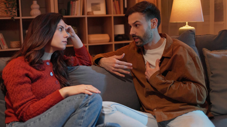 couple having a serious discussion on the couch