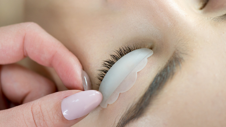 woman placing silicone pad on client's eye