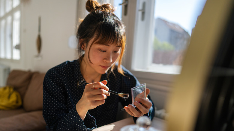 A woman doing her makeup