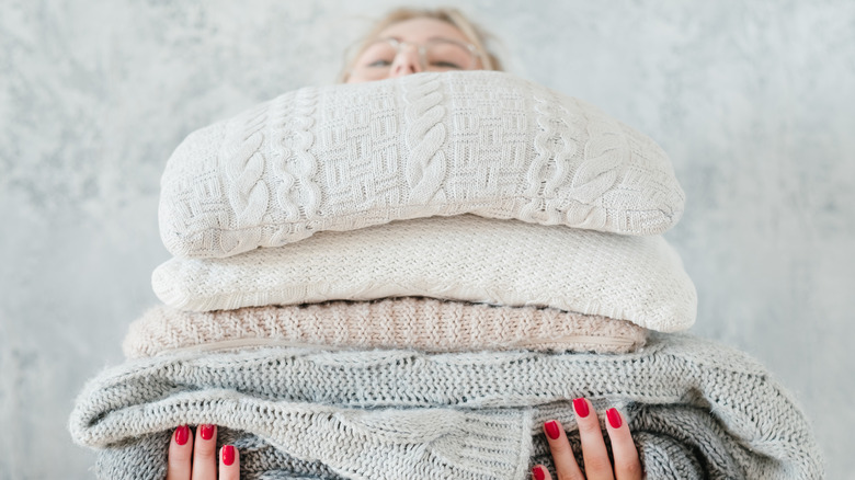 Woman holding clothes stack