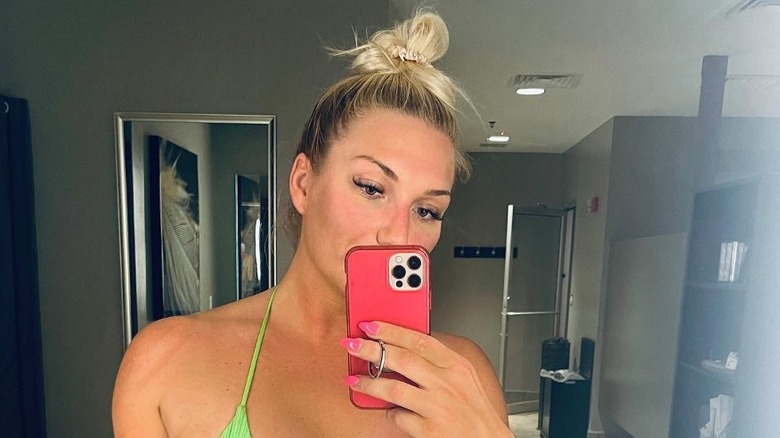 Brooke Hogan in a green swimsuit taking a selfie