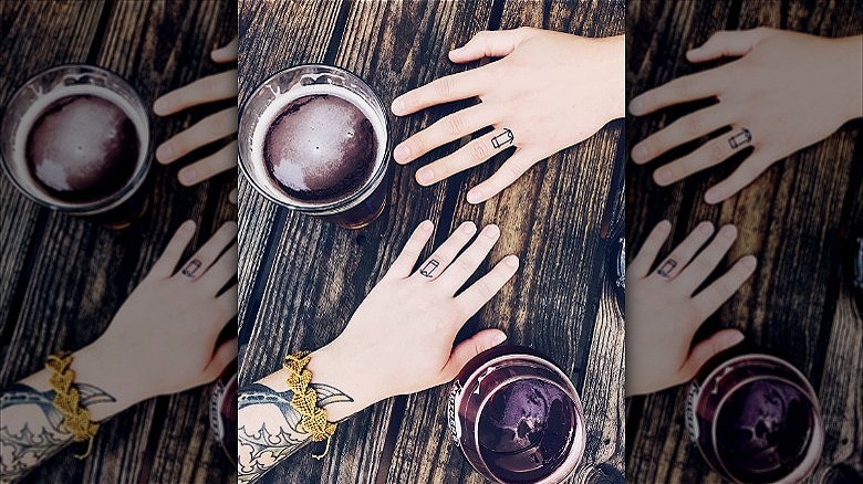 couple wearing wedding ring tattoos