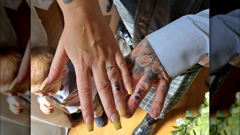couple wearing ring finger tattoos