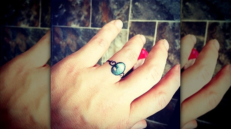 woman wearing wedding ring tattoo